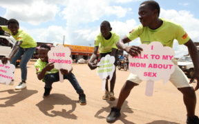صحت عامہ کے سفیر یوگنڈا کے ساتھ رقص کا ایک گروپ (PHAU) perform in the Luwero market to call attention to a pop-up health clinic providing HIV testing, Family Planning education and referrals, and de-worming kits.