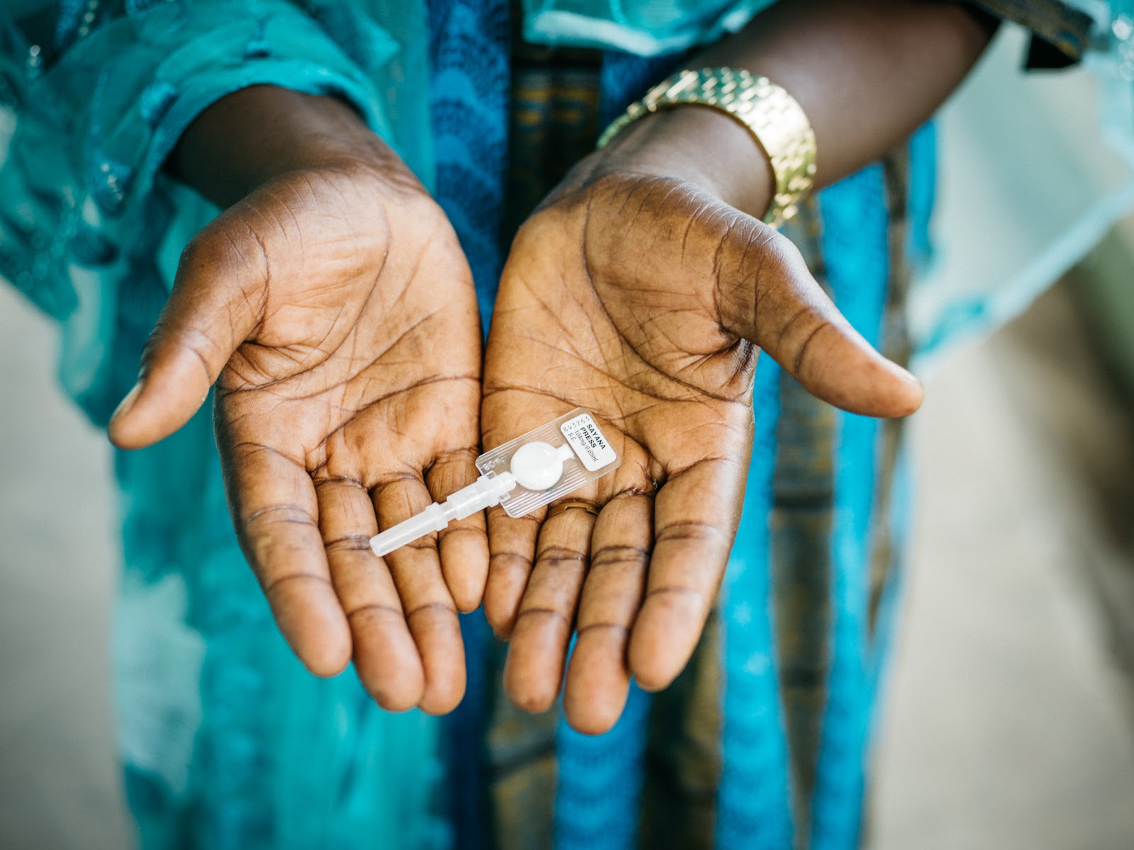 A woman in Senegal holds subcutaneous DMPA (DMPA-SC or brand name Sayana® Press) in both hands. Subcutaneous DMPA is a lower-dose, all-in-one injectable contraceptive that is administered every three months under the skin into the fat rather than into the muscle.