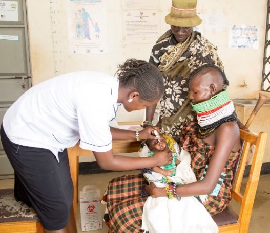 A couple receives information on healthy timing and spacing of pregnancy while their baby receives an immunization. Photo: Edna Mosiara, AFYA TIMIZA.