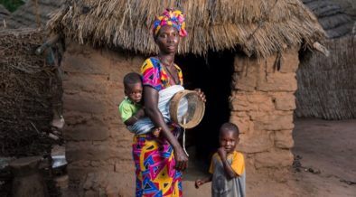 Uma mulher no Senegal que participou de um programa de empoderamento comunitário com seus filhos perto de sua casa. 2014, Jonathan Torgovnik/Getty Images/Imagens de empoderamento
