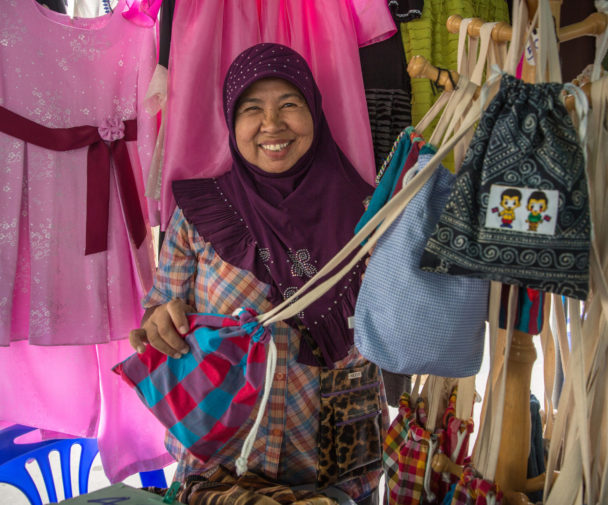 Aurapin Sakvichit montre ses vêtements à vendre sur un marché local en Thaïlande. Il n'est pas surprenant que les femmes et les filles les plus durement touchées par la pandémie soient celles qui ont toujours eu l'accès le plus restreint aux produits de santé reproductive.. Photo: Paula Bronstein / Getty Images / Images d'autonomisation
