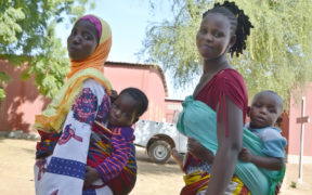 Two mothers in Burkina Faso carrying their children. Credit: Jhpiego