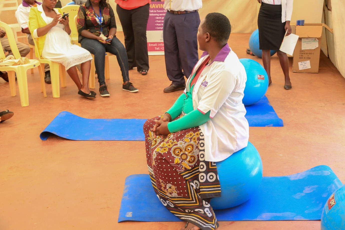 Lydia Masemo démontrant l'utilisation d'une balle de yoga pour faire de l'exercice pendant la grossesse.