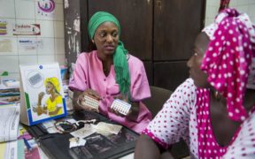 Un profesional de planificación familiar senegalés mostrando píldoras anticonceptivas