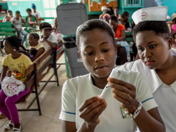 Jururawat wad dan pelajar jururawat memberi vaksinasi di Pusat Kesihatan La Fossette di Haiti. Kredit gambar: Karen Kasmauski, MCSP dan Jhpiego, melalui strim foto USAID Flickr.