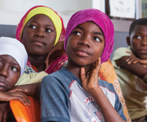 تین نوجوان لڑکیاں اور ایک لڑکا تعلیمی ماحول میں ایک ساتھ توجہ سے سن رہے ہیں۔. Crédit d'image: پی ایس آئی