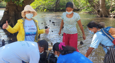 Equipe do projeto e participantes plantam mudas de mangue. Crédito da imagem: Fundação PATH Filipinas, Inc.