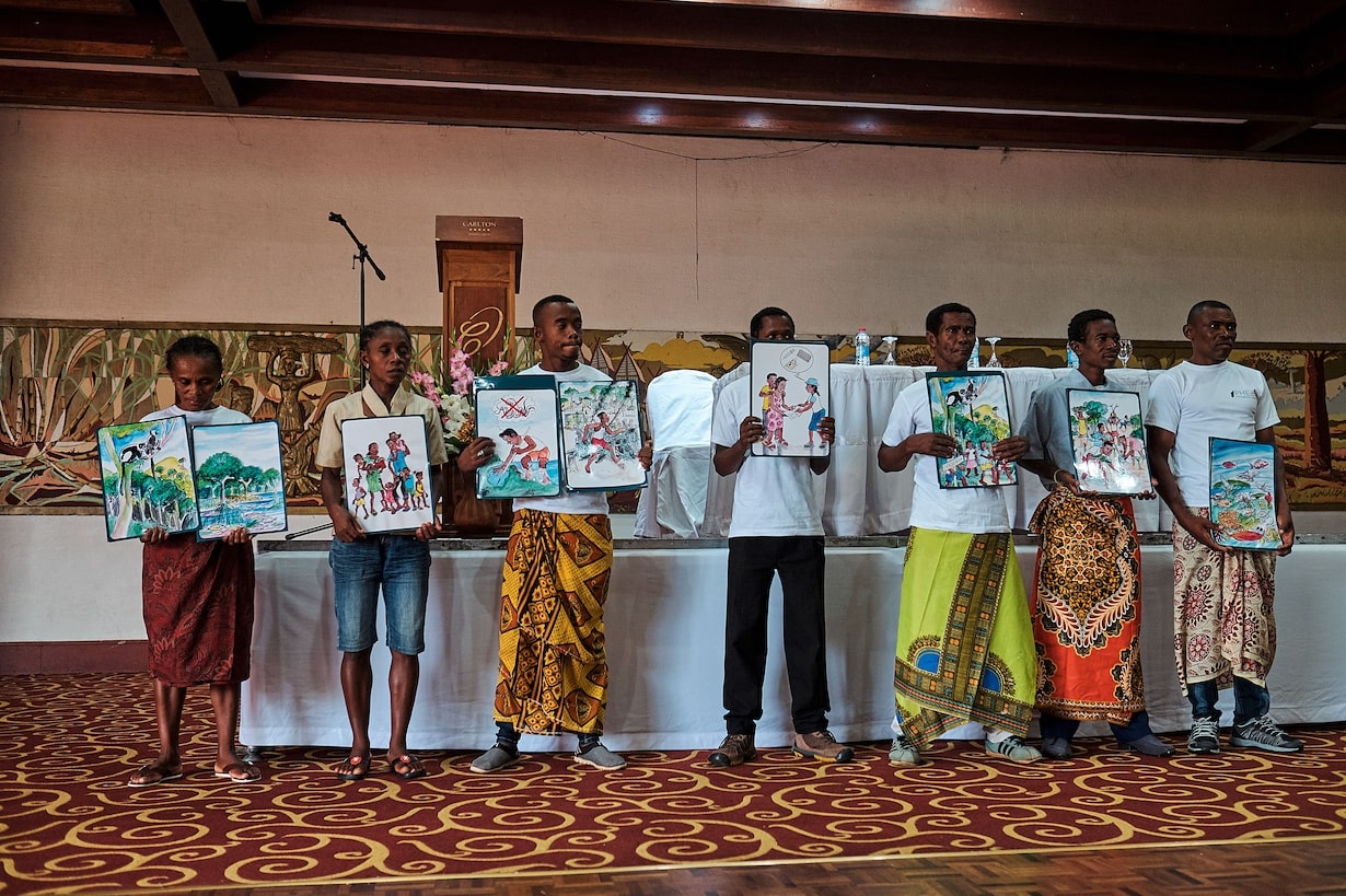 People holding paintings. Photo courtesy of Madagascar PHE Network