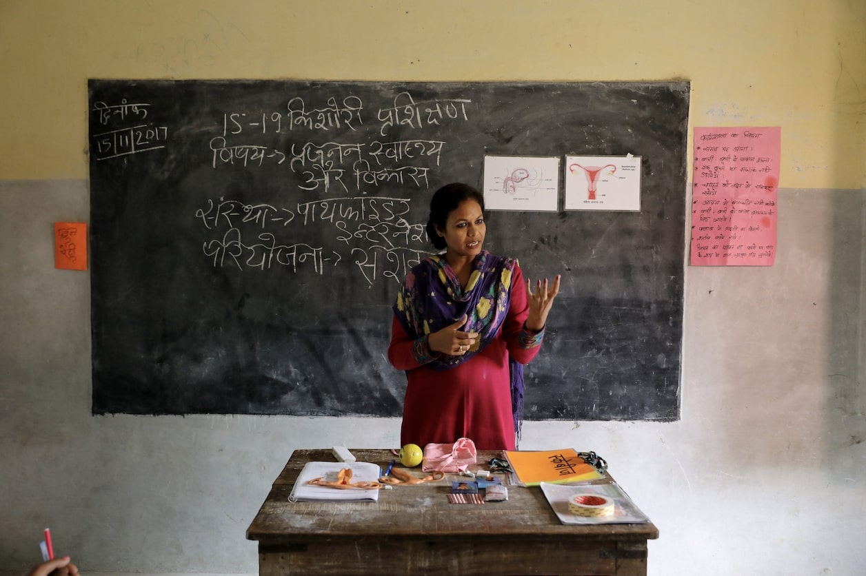 Un enseignant explique les systèmes de santé reproductive aux élèves d'une école de village. | Paula Bronstein / Getty Images / Images d'autonomisation