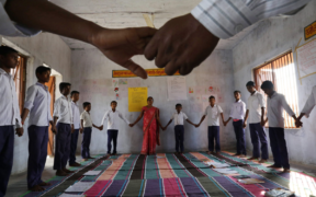 A classroom of boys at Middle School Keoti Balak hold hands
