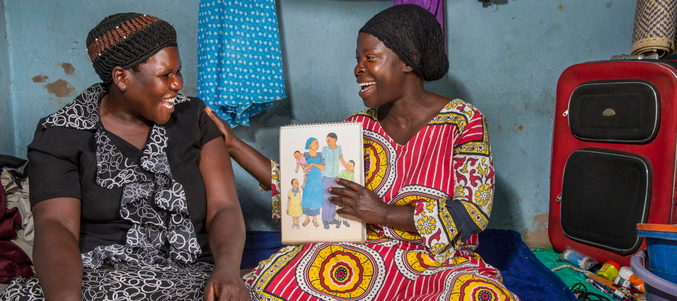 Community health worker during a home visit, providing family planning services and options to women in the community. This proactive program is supported by Reproductive Health Uganda.