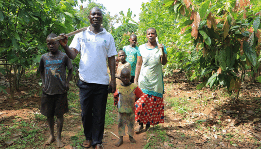Familia ya watu saba wanatembea pamoja kwenye miti nchini Uganda. Mkopo wa Picha: Charles Kabisa, Tengeneza upya Afrika
