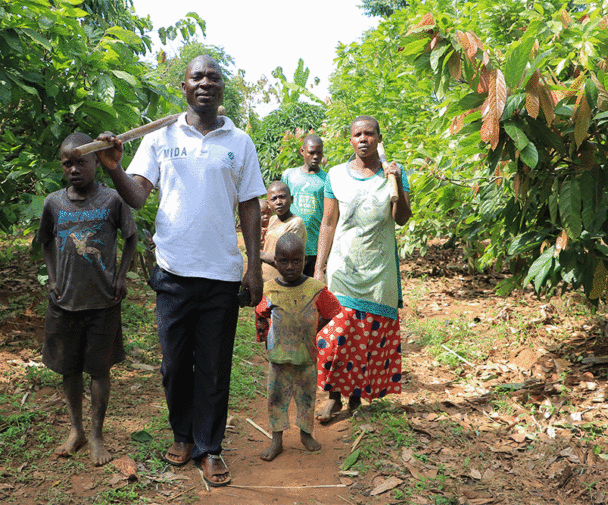 A family of seven walk together through the trees in Uganda. Photo Credit: Charles Kabiswa, Regenerate Africa
