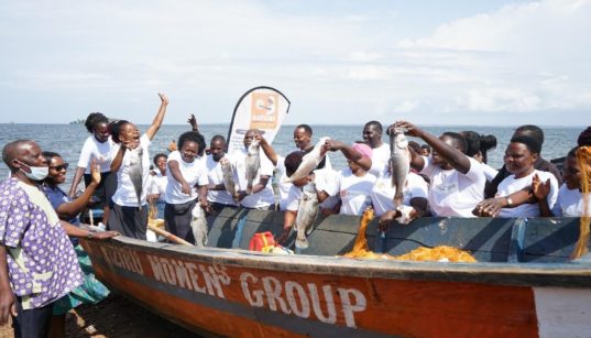 Several Kiziru Women’s Group members pose in their fishing boat while holding up fish in their hands for International Year of Artisanal Fisheries and Aquaculture 2022. Kiziru Women’s Group | Crédit: KWDT