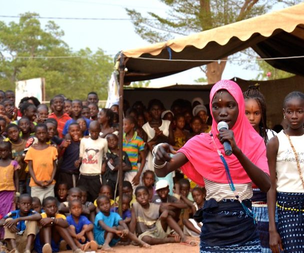 Performing a skit on early marriage, a girls’ team competes in a theater contest during the talent show portion of the Kolda Regional Fair, made possible by a Feed the Future grant. Photo by Lauren Seibert, Peace Corps, courtesy of Flickr