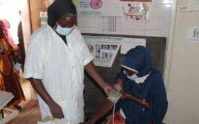 A health worker measuring a woman's blood pressure Integrated Social and Behavior Change