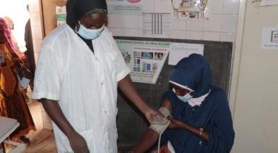 A health worker measuring a woman's blood pressure Integrated Social and Behavior Change