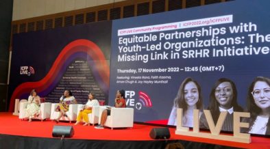 Vineeta Rana, Faith Kaoma, Aman Chugh, and Joy Hayley Munthali (far right) sitting on a red carpeted stage at ICFP for a panel discussion hosted by the We Trust You(th) Initiative, Engender Health and the YP Foundation from India on partnering with youth. Thailand, 2022.