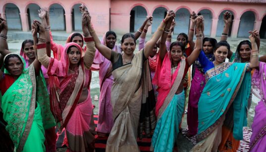 A group of Indian women raising their fists. Photo Credit: Images of Empowerment