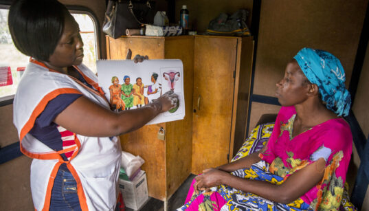 A woman learning family planning options like contraceptive implants at a rural village on the outskirts of Mombasa.